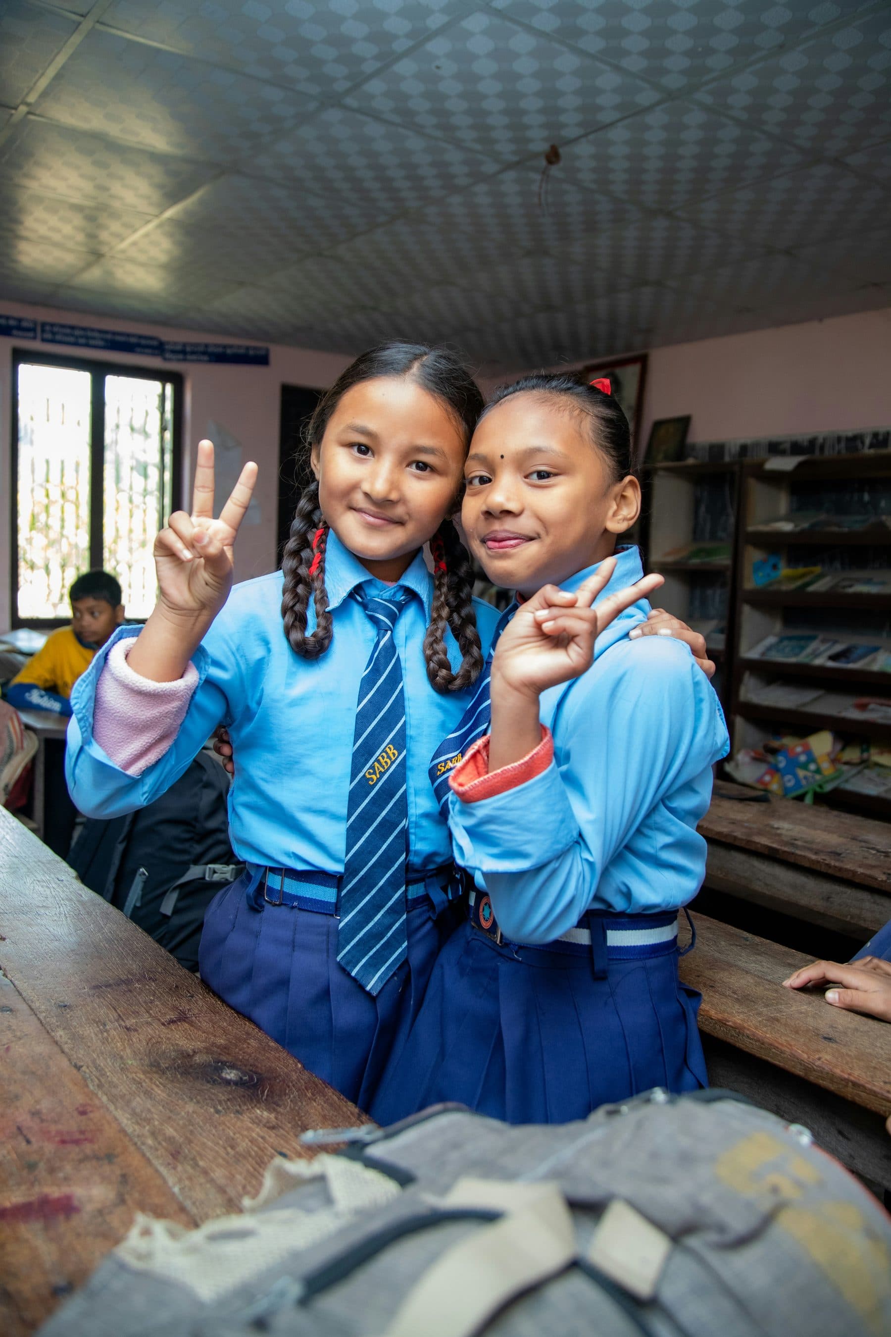 Two young students smiling together in class